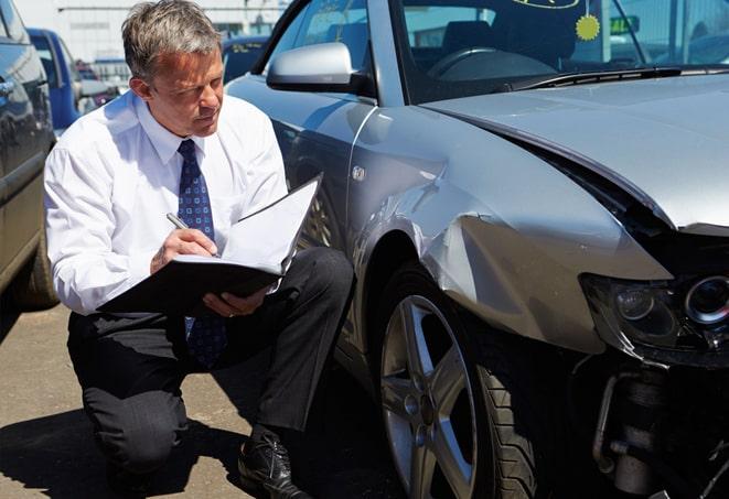 white sedan parked in front of a car insurance office